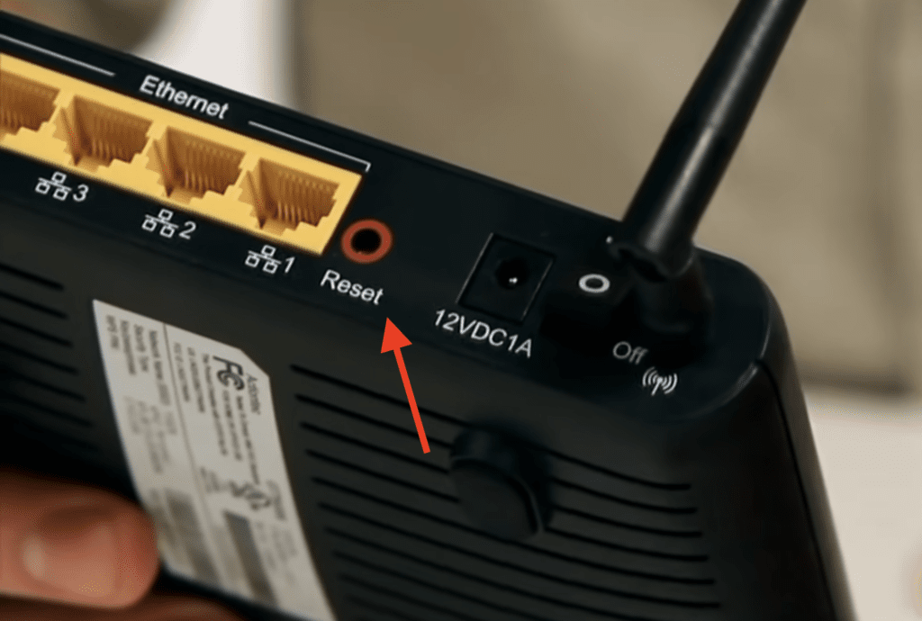 Photo of the reset button at the back of a router