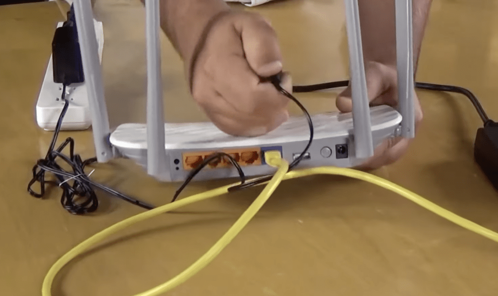 Photo of a person unplugging a power cable from a router