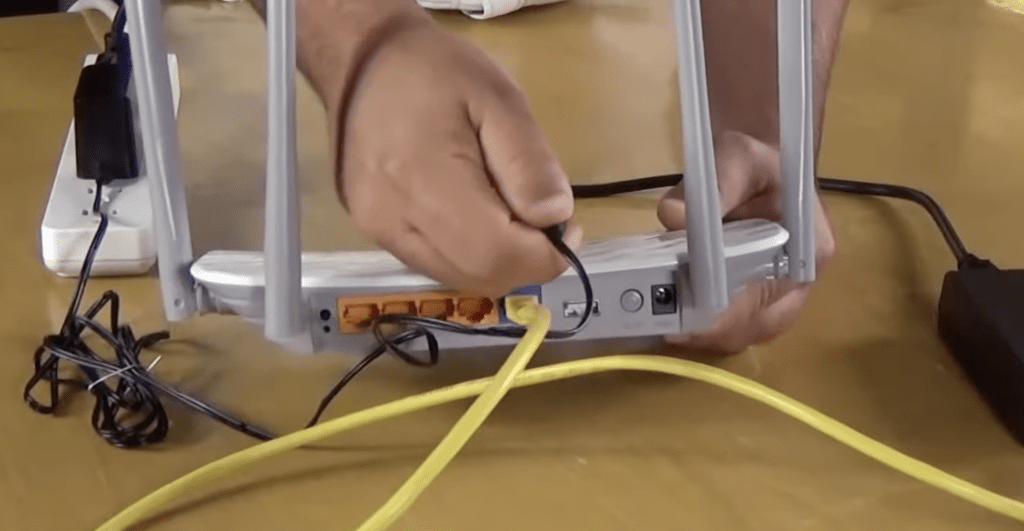 Photo of someone performing a power cycle on a Wi-Fi router