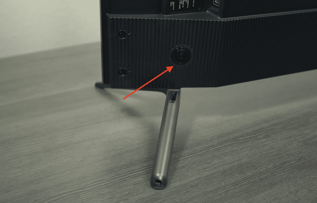 Photo of a power button at the right backside of a TCL Roku TV
