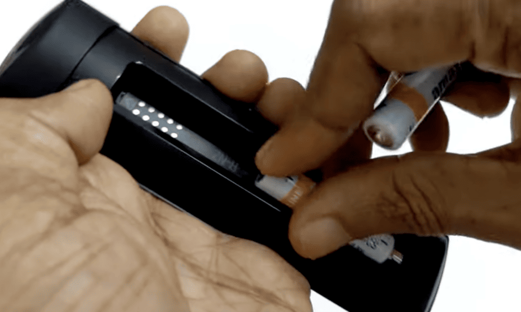 Photo of a person removing batteries from a firestick remote
