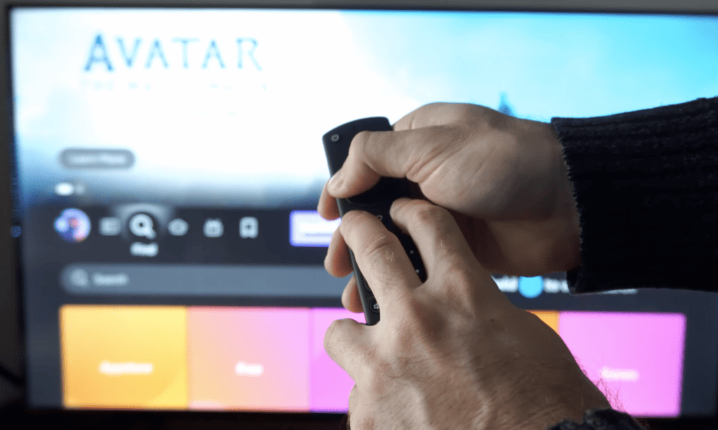 Photo of a person resetting a firestick remote by pressing the left, menu, and back buttons