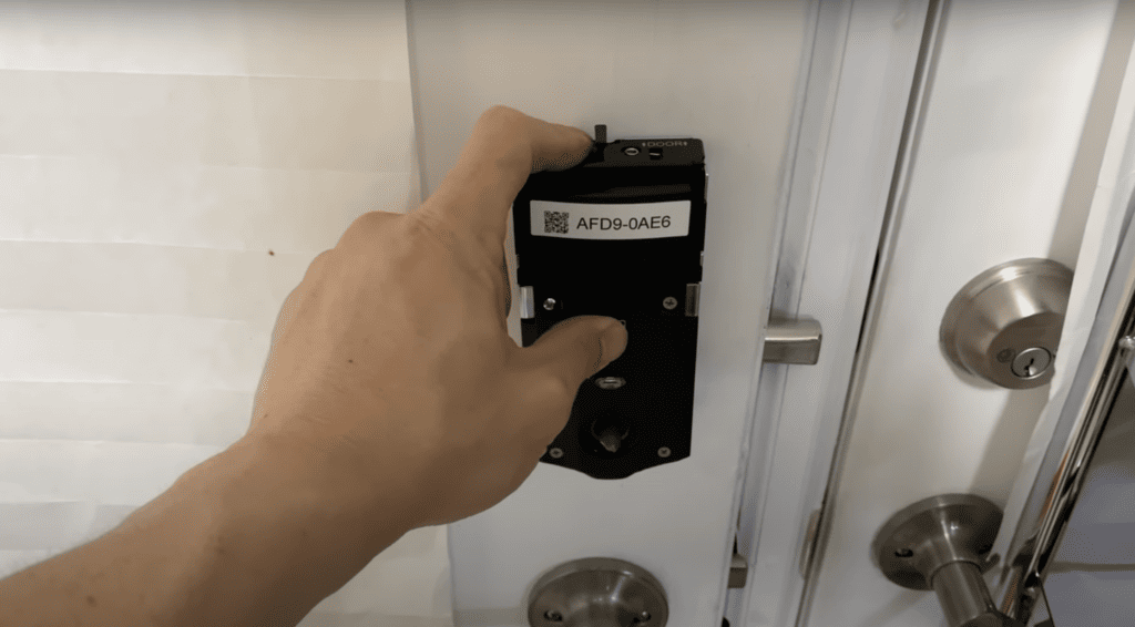 Man holding the button of a Kwikset smart lock model