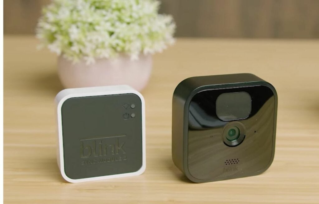 Blink camera and sync module on a wooden table