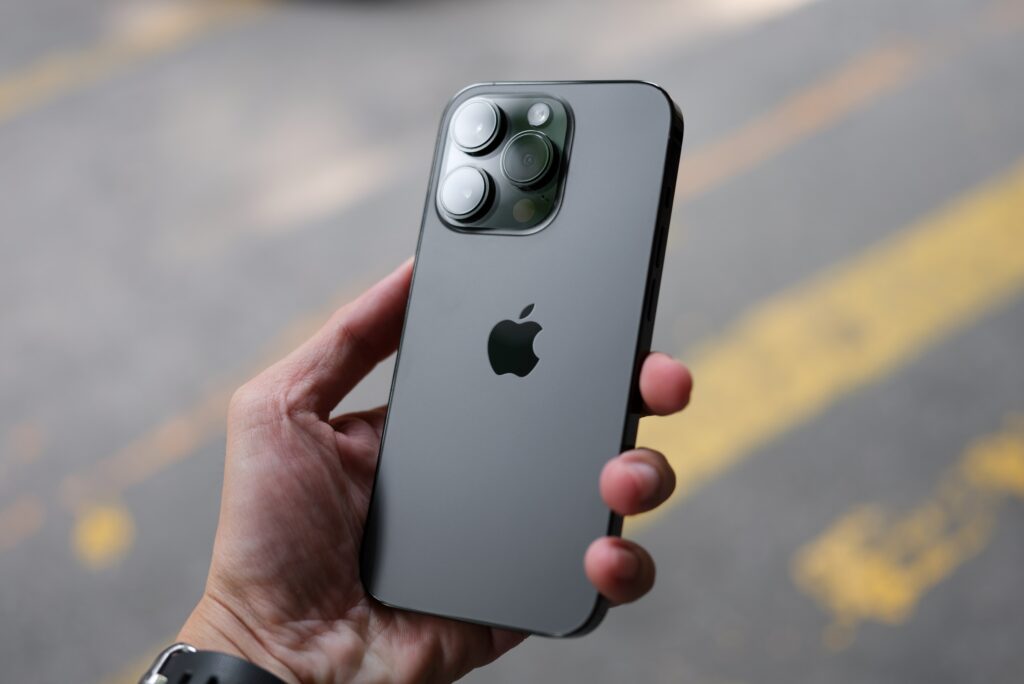 a hand holding and showing the back of an iPhone 14 Pro Max in Space Black