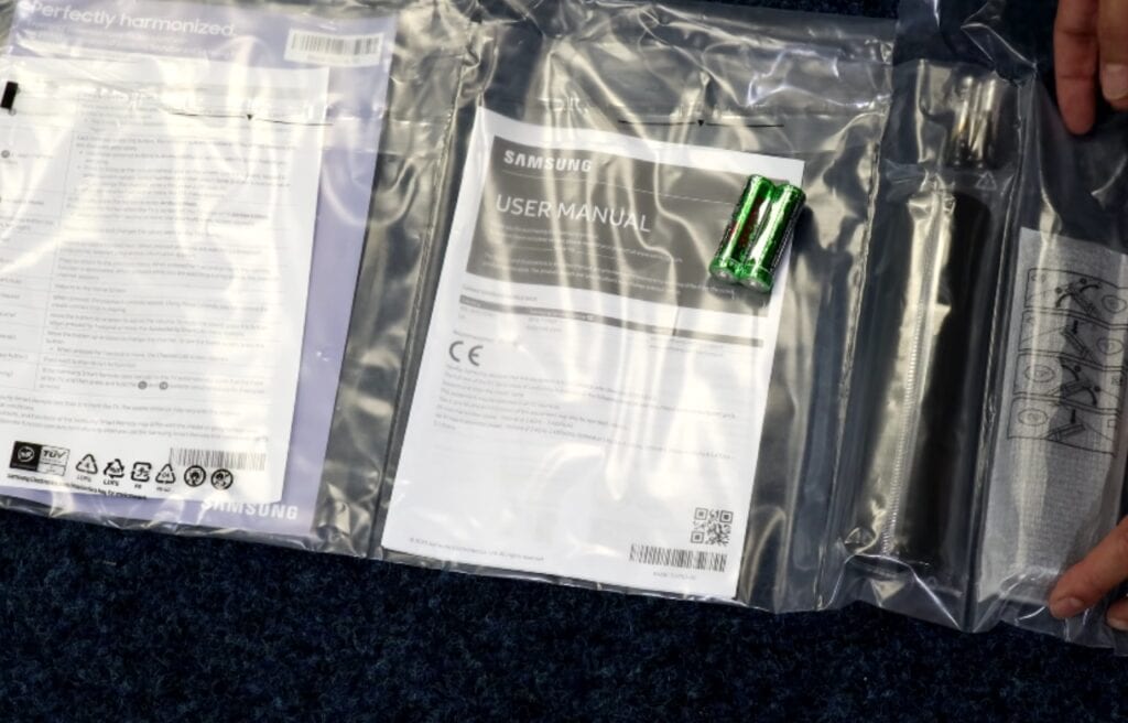 Samsung user manual and two AA batteries on a plastic pouch