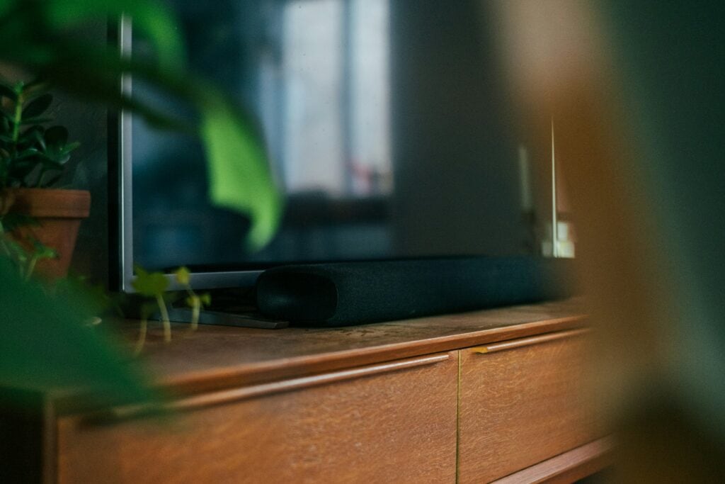 a black flatscreen TV and a soundbar on a wooden table