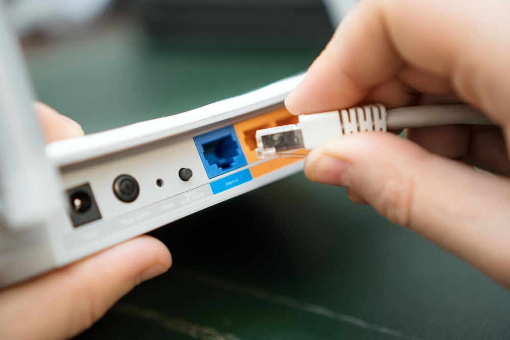 plugging an Ethernet cable on a Wi-Fi router
