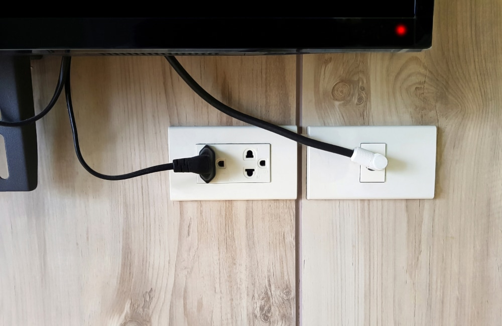 Power outlet of TV on the wooden wall